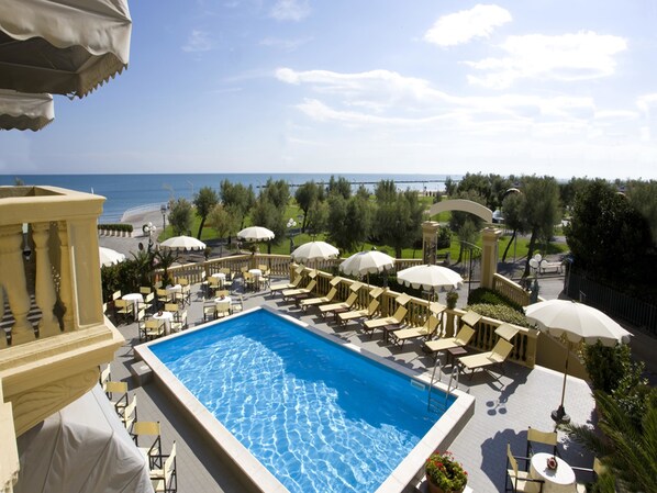 Piscine intérieure, piscine extérieure en saison, parasols