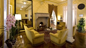 Un salón espacioso con chimenea, asientos cómodos y un espejo grande que refleja la habitación.