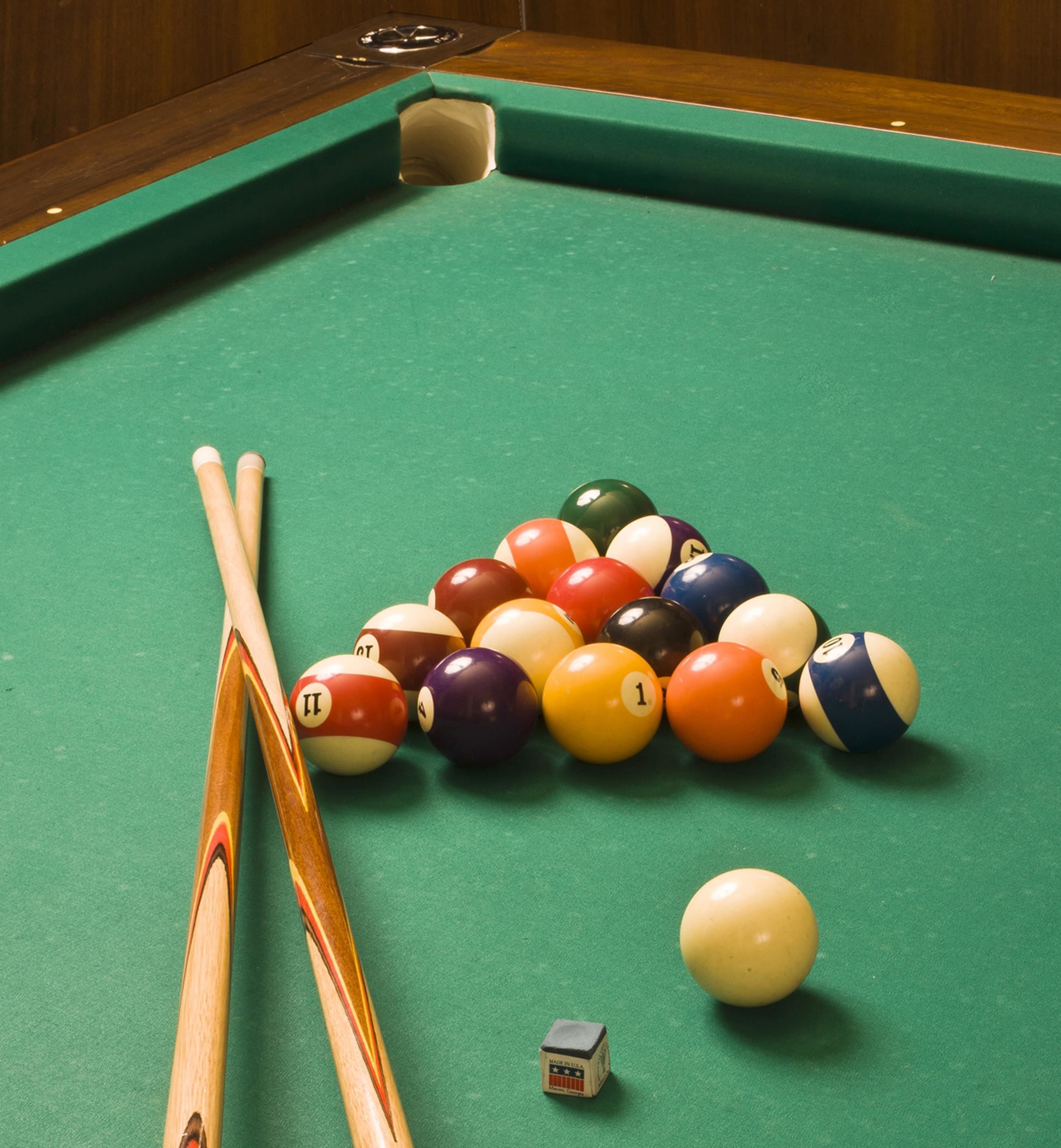 A pool table with balls and cues.