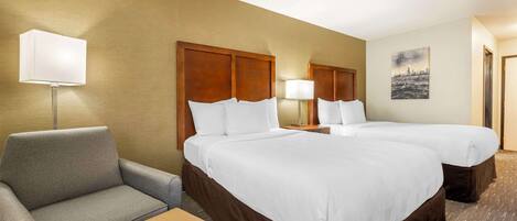 A hotel room with two beds, a sofa, a lamp, and a painting on the wall.