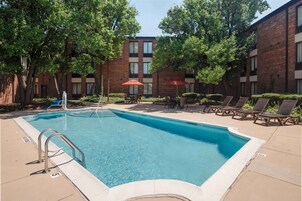 Una piscina al aire libre, sillones reclinables de piscina