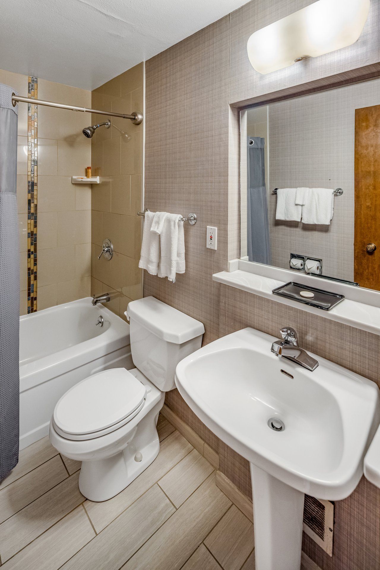 A modern bathroom with a bathtub, toilet, and sink.