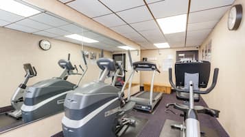 A gym with treadmills, ellipticals, and a rowing machine.