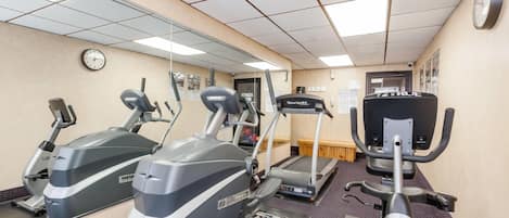 A gym with treadmills, ellipticals, and a rowing machine.