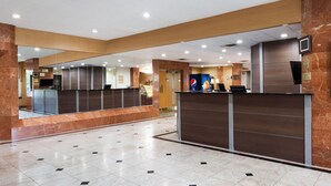 Un vestíbulo de hotel con mostrador de recepción, un espejo grande y el logotipo de Pepsi.