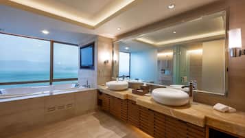 Un baño moderno con una bañera grande, dos lavamanos y un espejo amplio.