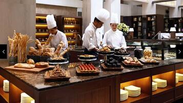 A buffet setup with various food items and chefs serving.
