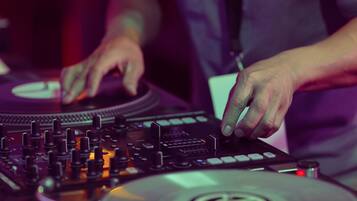 A close-up of a DJ mixing with a turntable and mixer.