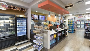 A grocery store interior with refrigerated sections, a checkout counter, and a beverage section.