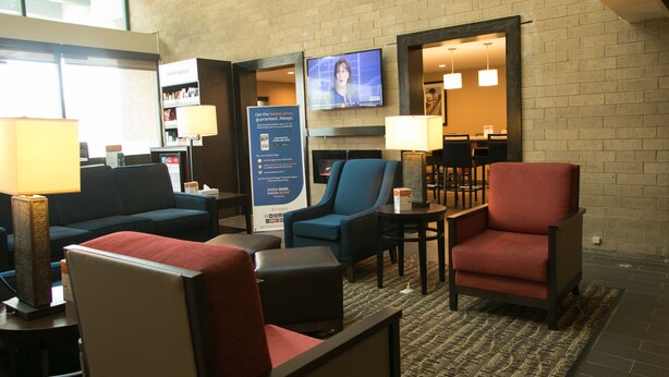 A hotel lobby with seating areas, a television, and a fireplace. - Comfort Suites Oakbrook Terrace - Chicago West (Villa Park)