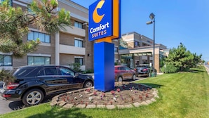 A Comfort Suites hotel sign, a parking lot, and a building with multiple windows. - Comfort Suites Oakbrook Terrace - Chicago West (Villa Park)