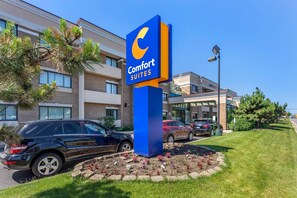 A Comfort Suites hotel sign with a modern building in the background. - Comfort Suites Oakbrook Terrace - Chicago West (Villa Park)