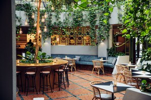 An indoor dining area with tables and chairs, a wooden bar, and a seating area with a sofa. - Best Western Plus Vasterviks Stadshotell (Vastervik)