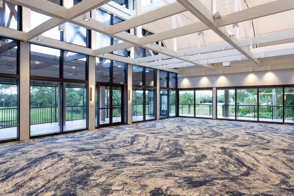 A spacious indoor area with large windows, a high ceiling, and a patterned carpet. - Orlando World Center Marriott (Orlando)