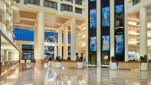 A spacious lobby with high ceilings, large windows, and a central atrium. - Orlando World Center Marriott (Orlando)