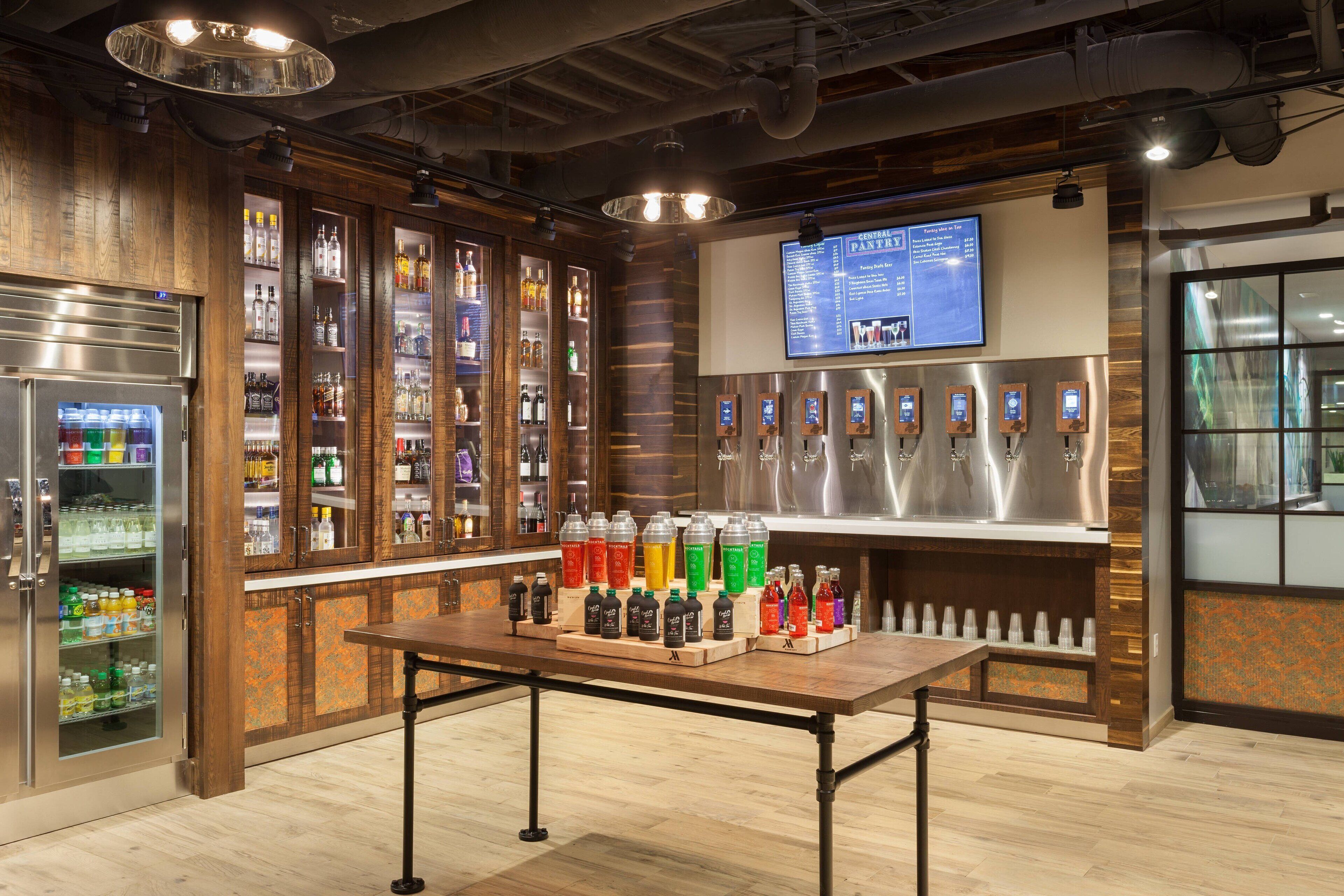 A bar area with a wooden interior, a refrigerated display case, and a menu board.