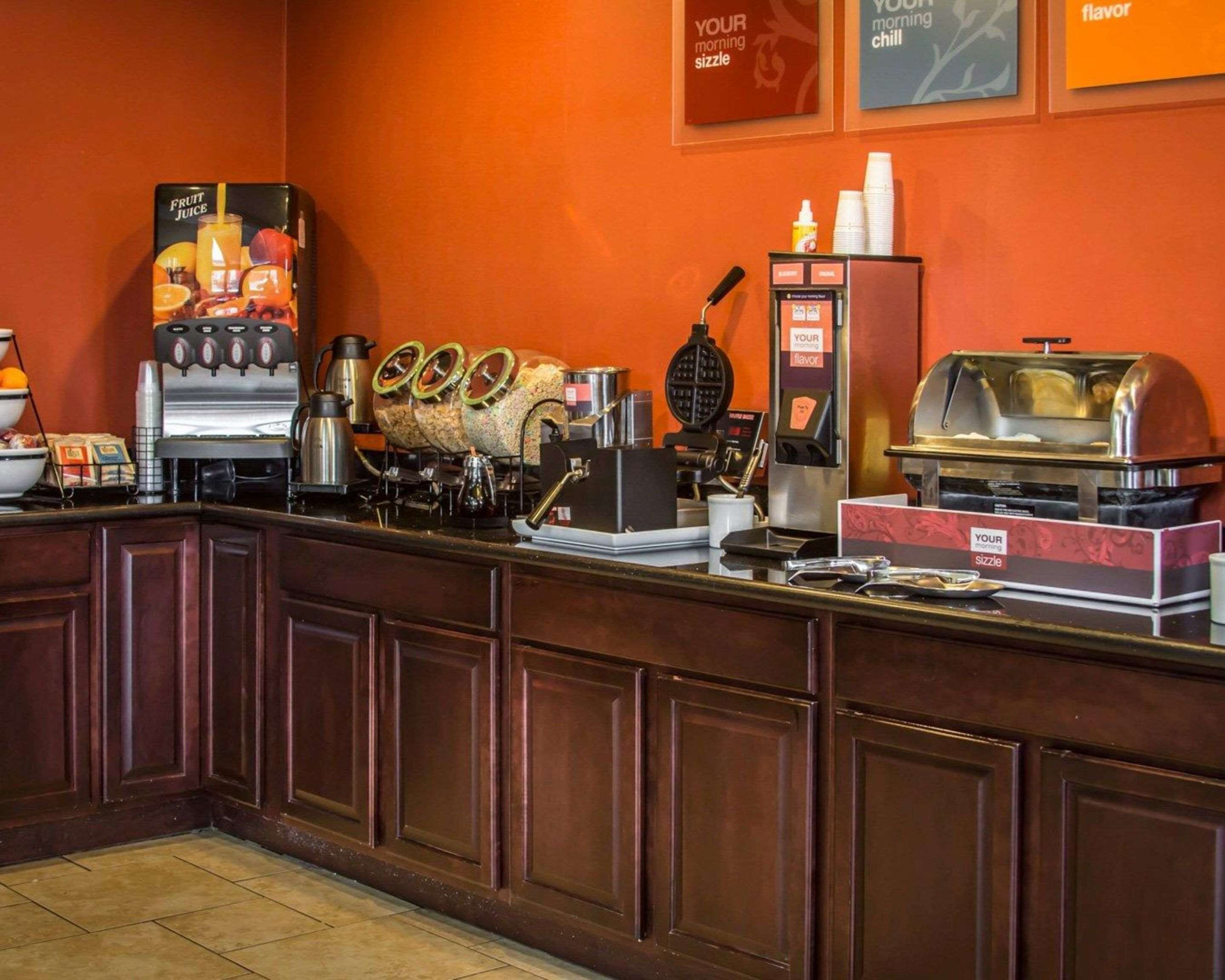 Ein Frühstücksbuffet mit Kaffeemaschine, Waffeleisen und einer heißen Theke.