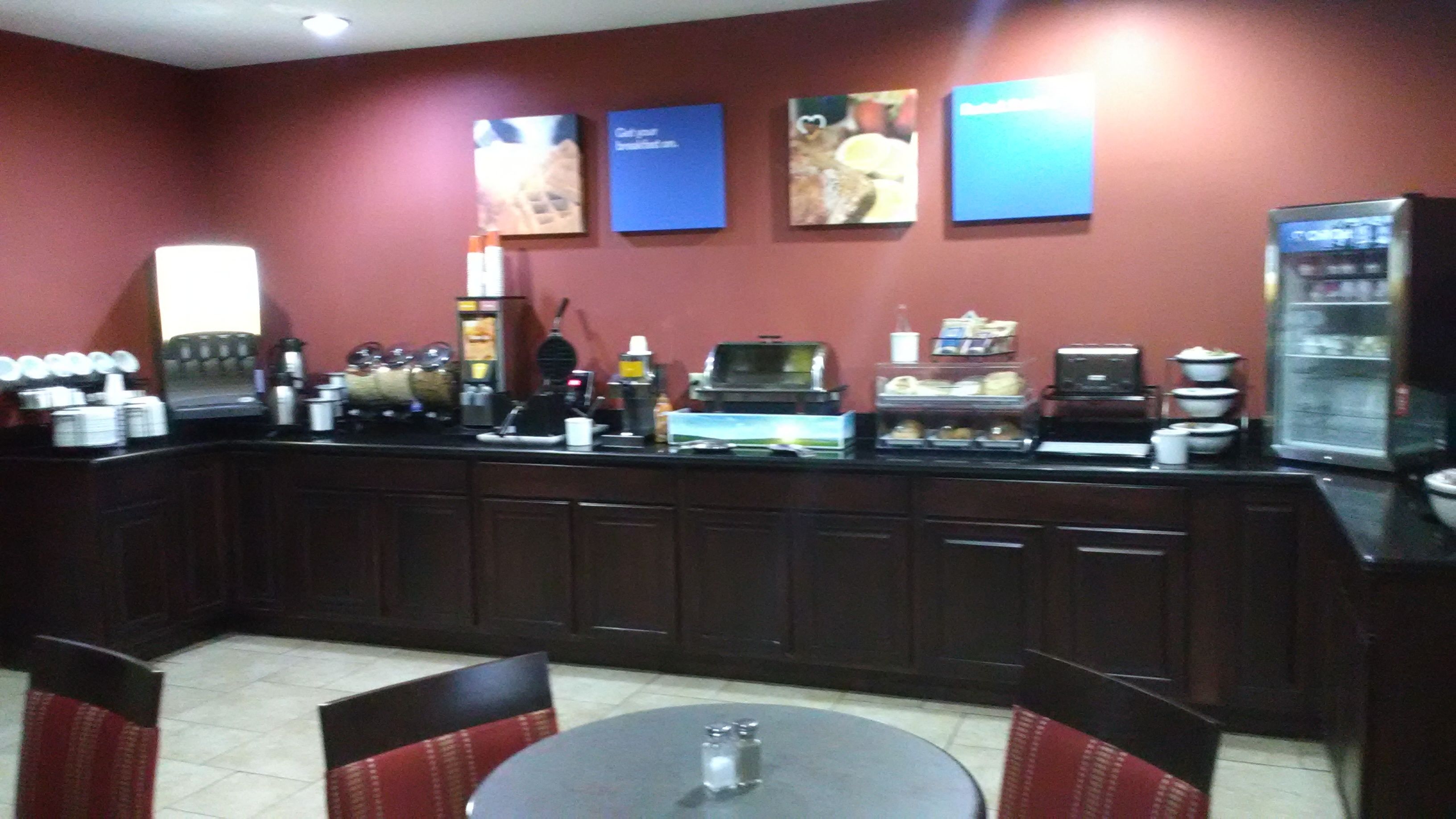 A restaurant with a counter, seating area, and various food and drink items.