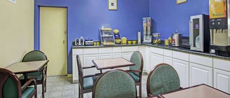 A diner with blue walls, a coffee machine, and a breakfast bar.