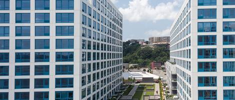 A modern building with a grid of windows and a rooftop garden.