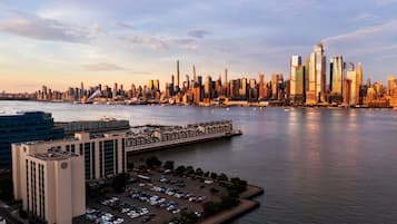 A city skyline with modern skyscrapers, a waterfront, and a parking lot.