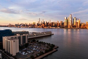 A city skyline with modern skyscrapers, a waterfront, and a parking lot.