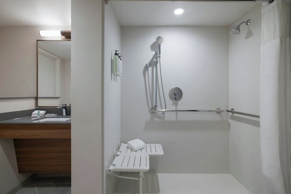 A modern bathroom with a shower, a sink with a mirror, and a towel rack.