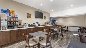 A hotel breakfast area with a counter displaying various food items and a television mounted on the wall. - Best Western Redondo Beach Galleria Hotel - Beach City LA (Redondo Beach)