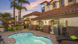 A hotel with a swimming pool, outdoor seating, and palm trees. - Best Western Redondo Beach Galleria Hotel - Beach City LA (Redondo Beach)