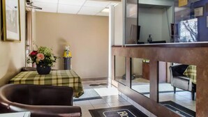 A hotel lobby with a checkered table, a potted plant, and a reception desk. - Rodeway Inn Allentown South (Allentown)