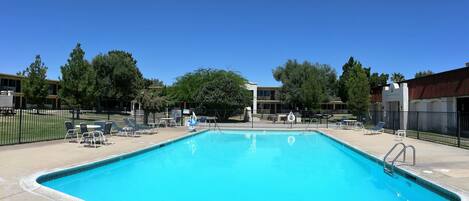 Una piscina rectangular con agua azul cristalina, rodeada por una solana de hormigón.