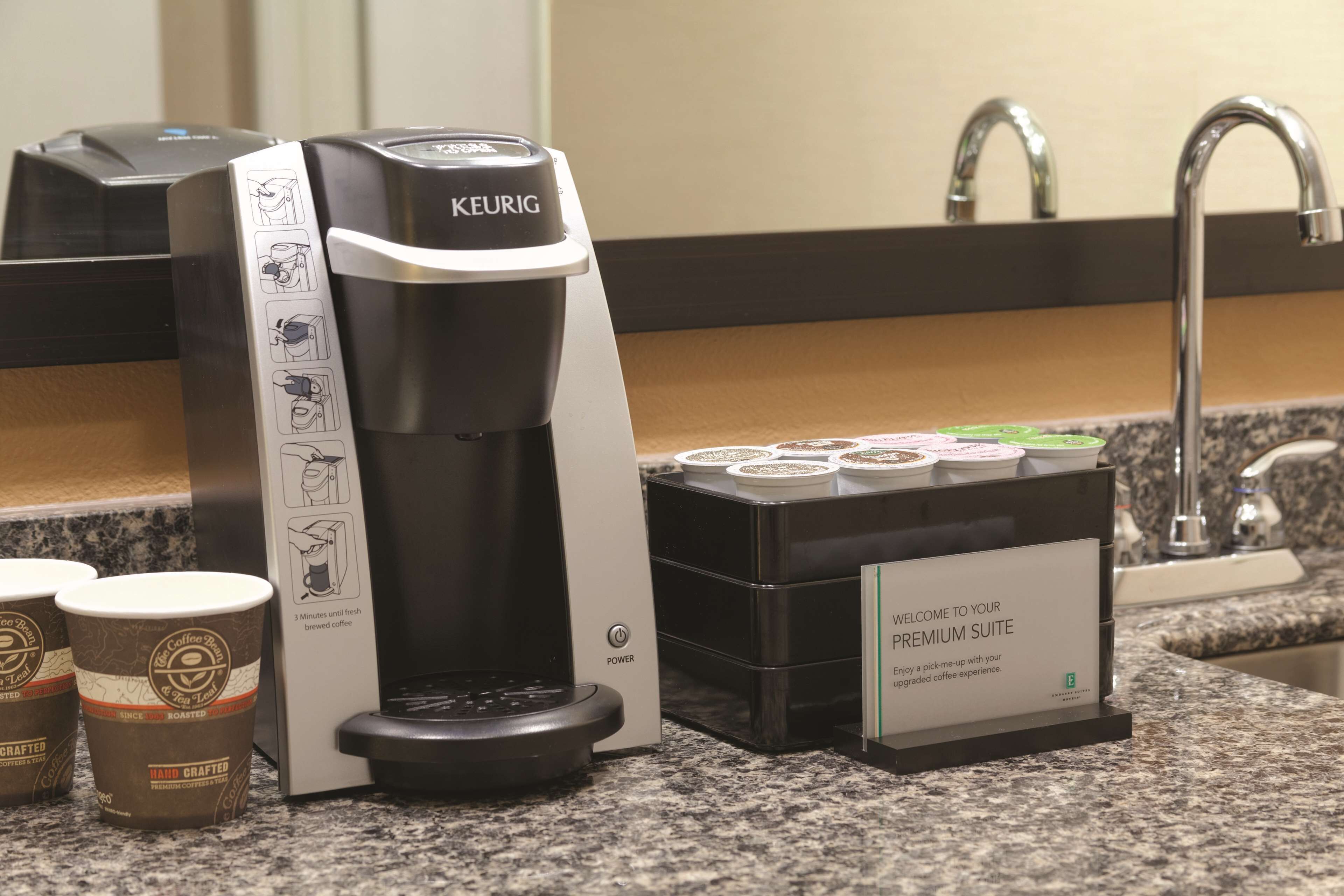 A Keurig coffee machine with a coffee pod holder and a welcome sign for the Premium Suite.