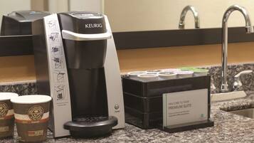 A Keurig coffee machine with a coffee pod holder and a welcome sign for the Premium Suite.