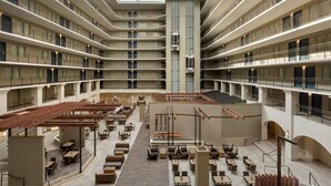 A multi-level hotel atrium with a central open space, multiple balconies, and a variety of seating arrangements. - Embassy Suites by Hilton Milpitas Silicon Valley (Milpitas)