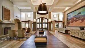 A spacious lobby with a grand chandelier, a fireplace, and a large painting on the wall. - Embassy Suites by Hilton Milpitas Silicon Valley (Milpitas)