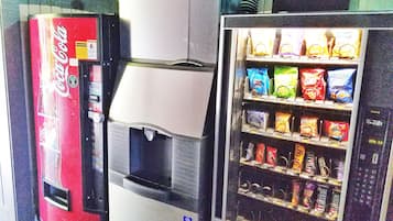 Un distributeur automatique de collations et un réfrigérateur à boissons, avec des Coca-Cola.