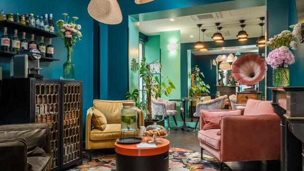 A modern lounge area with leather sofas, a round coffee table, and a variety of decorative items including a large vase of flowers. - Archétype Etoile (Paris)