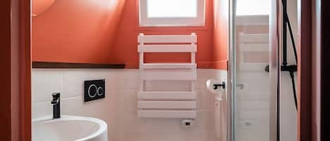 A bathroom with a white sink, toilet, and a towel rack.