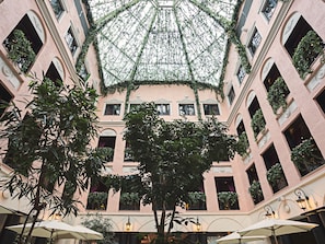 A multi-level atrium with a glass ceiling, allowing natural light to illuminate the space.