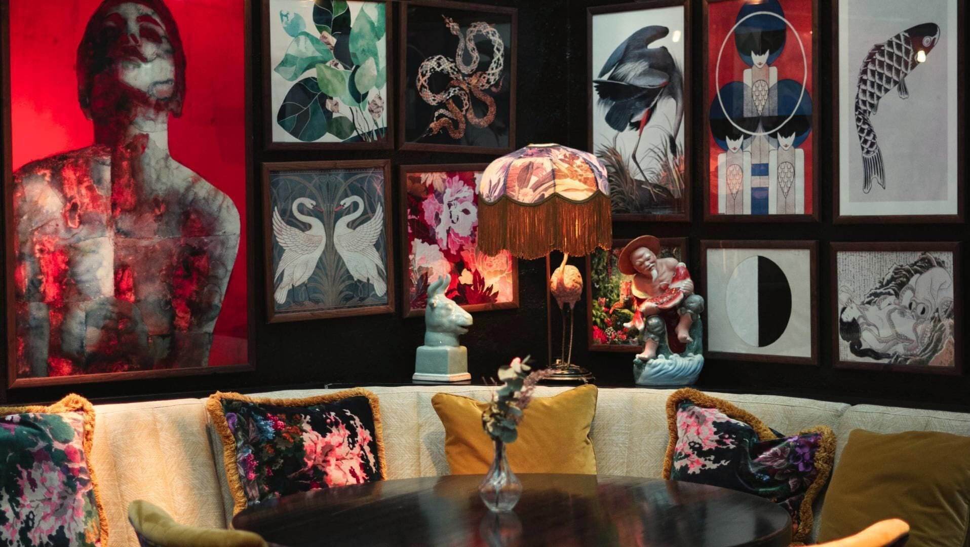Una habitación con un sofá, una mesa y varias obras de arte enmarcadas en las paredes.