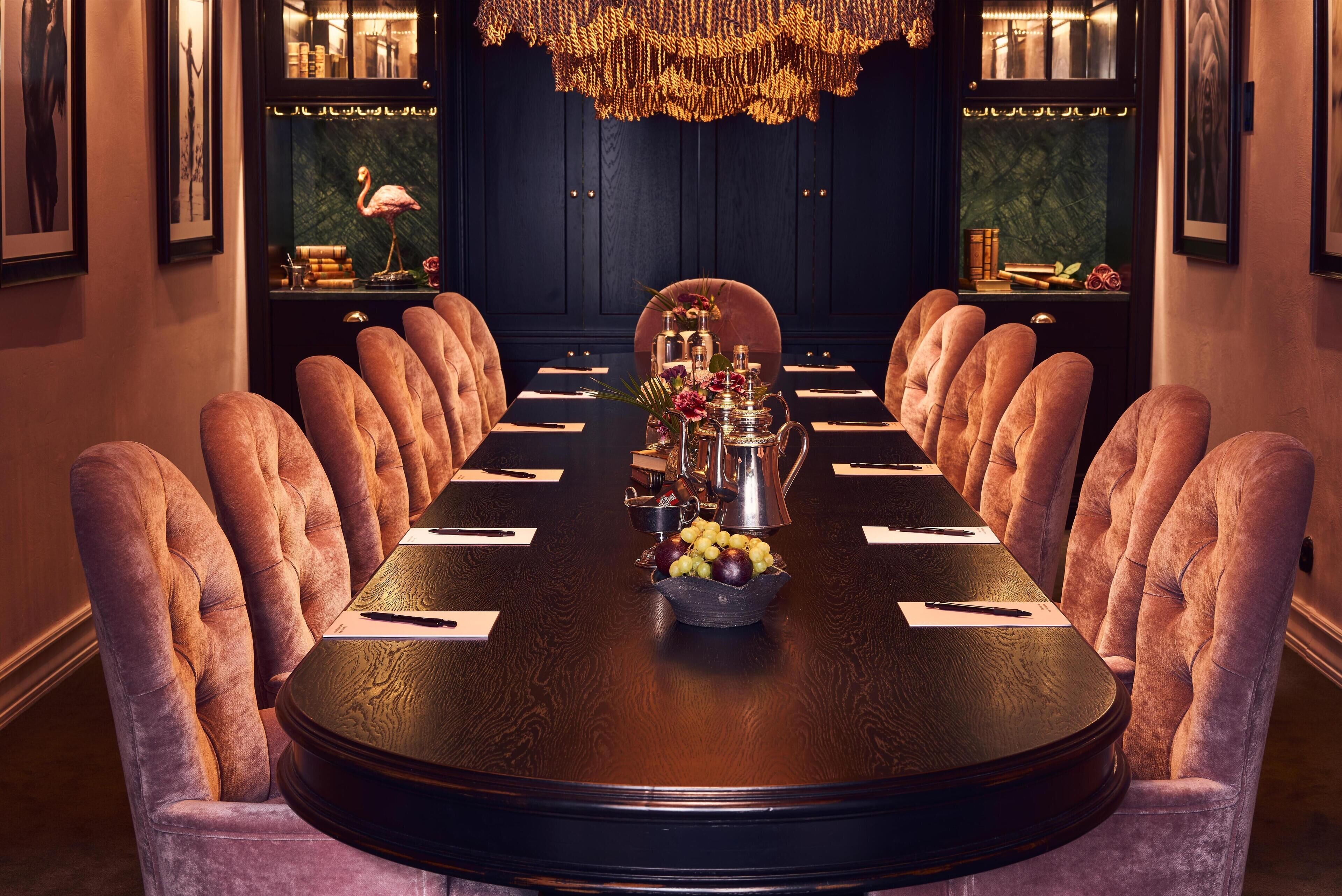 Ein eleganter Speisesaal mit einem runden Tisch, Samtstühlen und einer Kristallleuchter.
