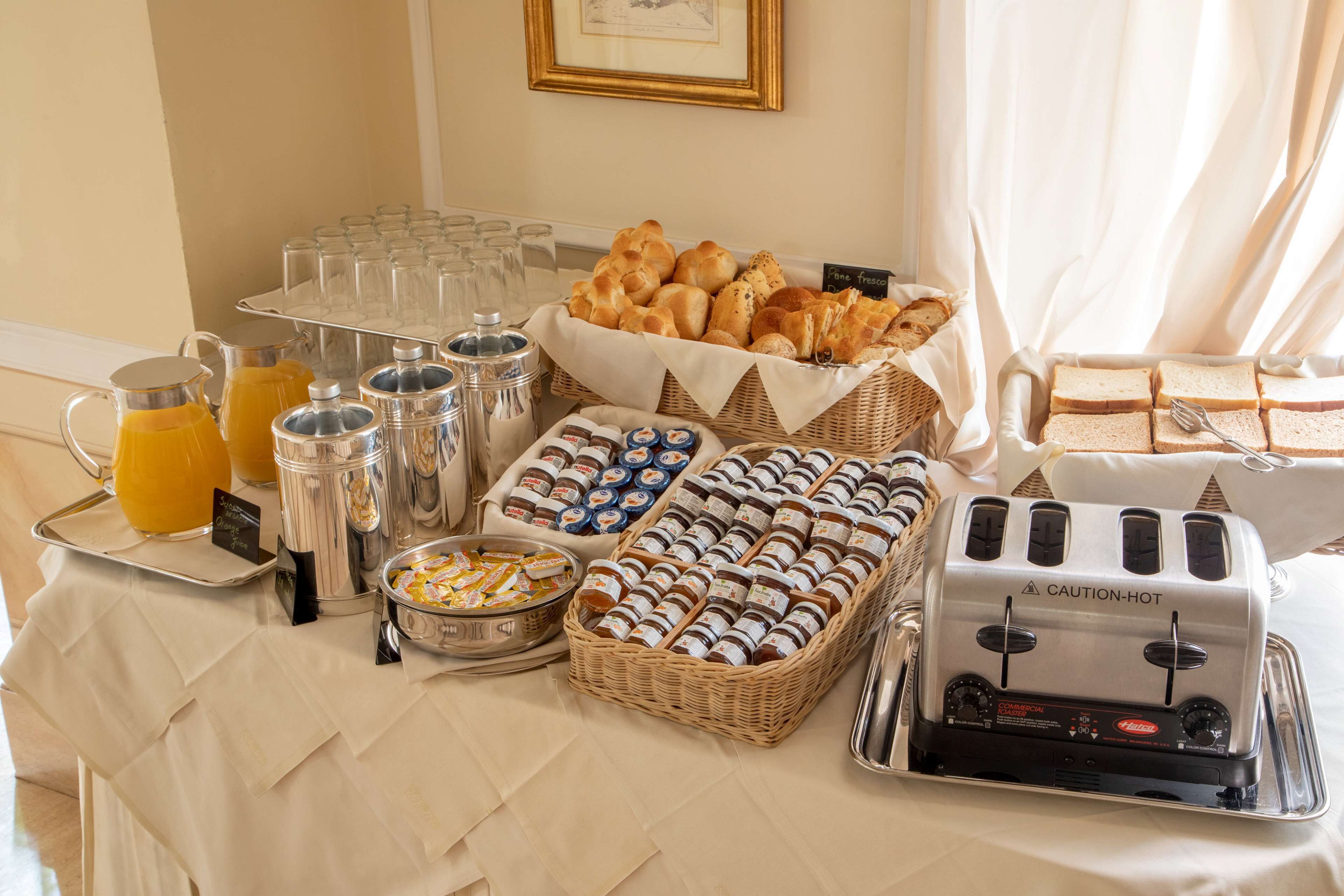 Un bufé de desayuno con diversas opciones de comida, como pan, pasteles y salsas.