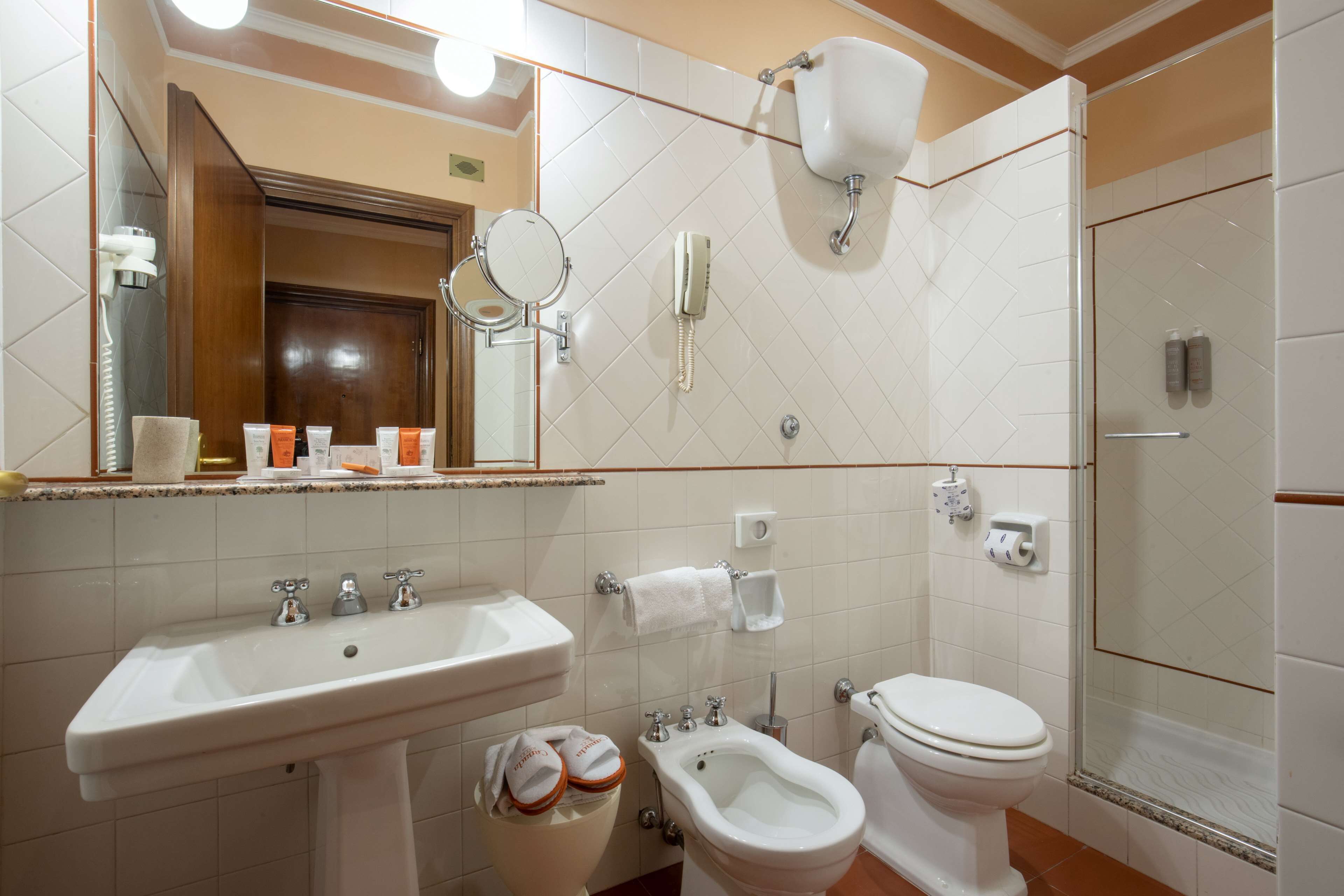 Une salle de bain équipée d’un lavabo, d’un bidet, de toilettes et d’un espace douche.