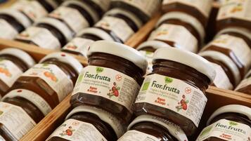 Multiple jars of Fior.fruutta strawberry jam in wooden crates.