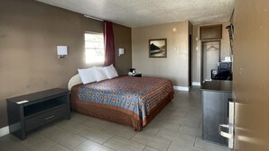 Un dormitorio con cama, mesita de noche y cómoda.