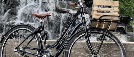 Una bicicleta con una cesta de madera en la parte delantera, estacionada frente a una cascada.