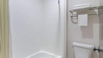 A bathroom with a bathtub, toilet, and a towel rack with towels.