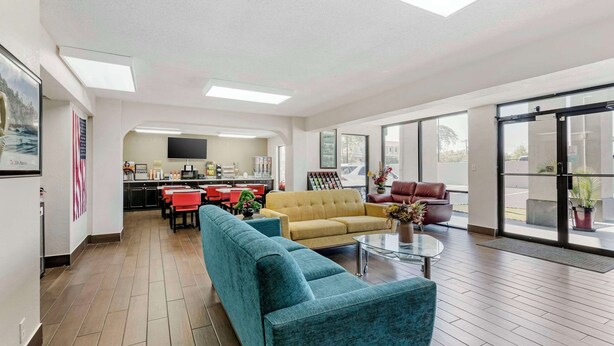 A spacious living area with a sofa, coffee table, and a kitchen in the background.