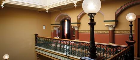 A grand staircase with ornate railings and decorative lighting fixtures.