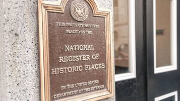 A plaque on a building wall stating it is a National Register of Historic Places.